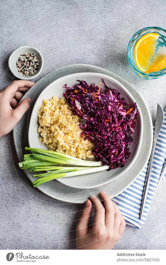 Healthy diet lunch set with raw salad and boiled bulgur food health red cabbage carrot plate ceramic nutrition fresh green onion citrus water side cloth napkin