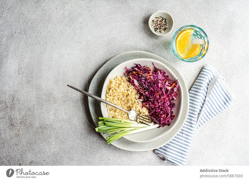 Healthy lunch with red cabbage salad and bulgur plate carrot raw healthy meal fresh vegetable diet nutrition modern water glass green onion napkin gray vibrant