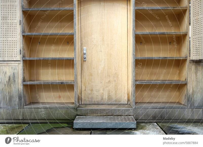 Wooden paneling with wooden door and empty shelves of a cashier's booth made of light natural wood at shaft XII of Zollverein colliery in Ruhr area in North Rhine-Westphalia in Germany