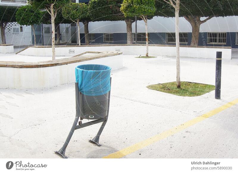 Dancing trash can in a parking lot, it appears to have been hit by a car and is standing crooked on 2 legs Environment waste rubbish bin Trash dance Arrangement