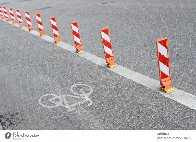 Red and white warning beacons next to bicycle lane Reddish white Striped Warning beacon Exterior shot Structures and shapes Deserted Pictogram Bicycle Cycling