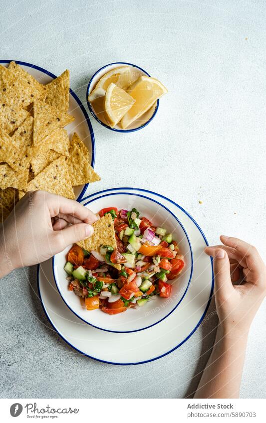 Fresh tomato avocado salsa with corn chips coriander onion lemon juice unrecognizable snack appetizer mexican cuisine fresh chopped chunk bowl vibrant anonymous