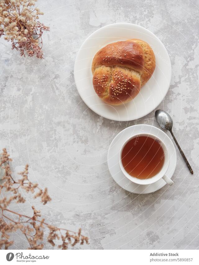 Autumn tea time with sesame bread and hot tea autumn cup baked texture surface dried flower cozy comfort beverage breakfast top view snack pastry bakery ceramic