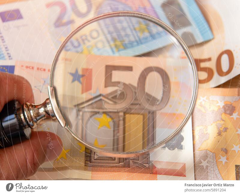 Magnifying Glass Over 50 Euro Banknote magnifying glass euro banknote currency money hand finance detail closeup security feature examination inspection