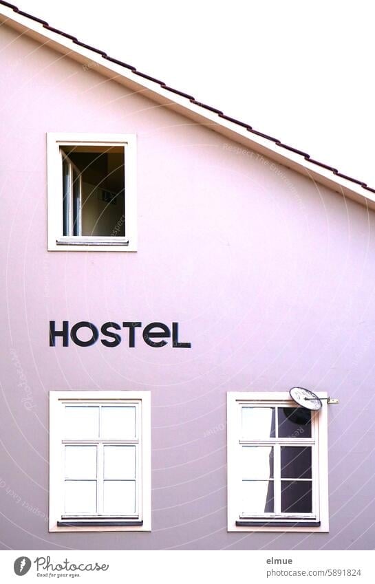 Part of a building with windows and HOSTEL lettering Hostel Stay overnight at a reasonable price price-conscious overnight stay low-priced spend the night