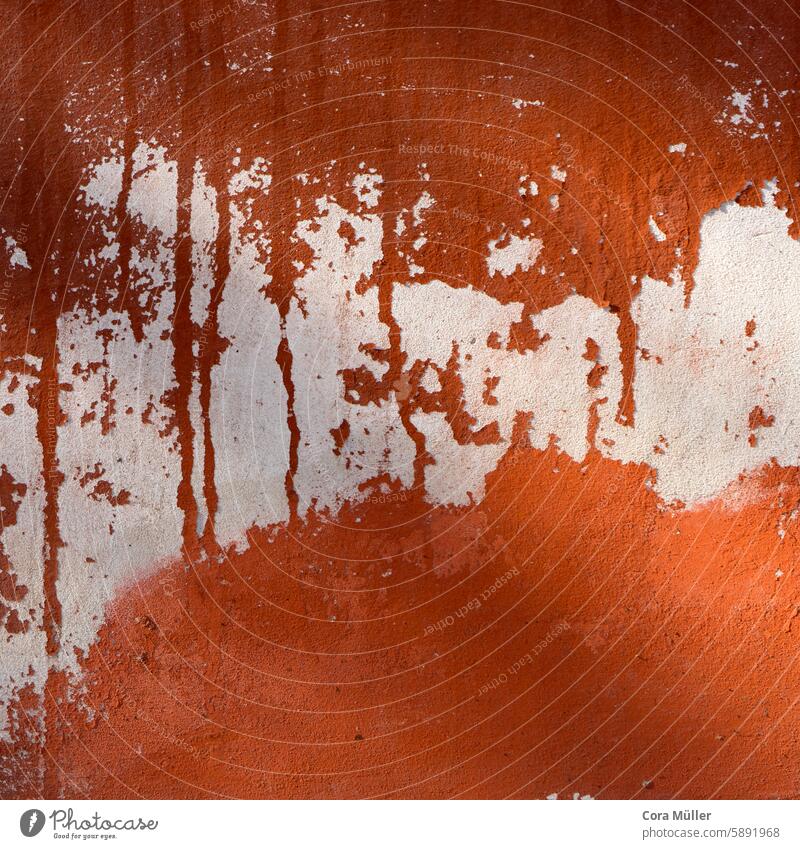 Wall with layers of red, orange and white paint weathered by the sun Red Orange Colour wall paint background Abstract Weathered layers of paint pile Colours