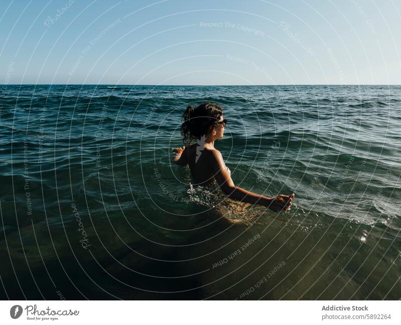 Young woman enjoying a swim in the ocean during summer holiday water sea blue clear sky happiness relaxation outdoor nature horizon leisure vacation travel