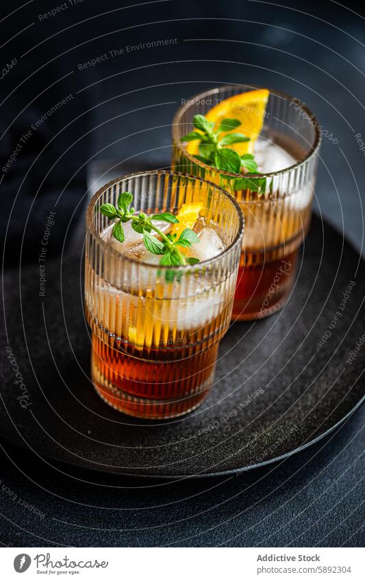 Elegant cherry liqueur cocktail with tonic, ice, and fresh mint summer orange slice leaf glass beverage drink refreshment alcohol bar garnish presentation