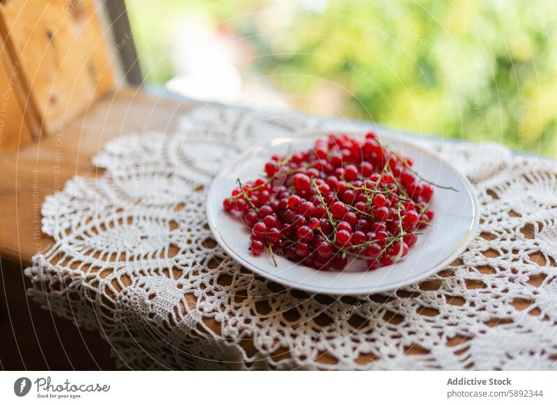 Fresh redcurrant berries on a lace tablecloth in natural light berry plate fresh summer vibrant color fruit healthy organic ripe juicy wooden decoration