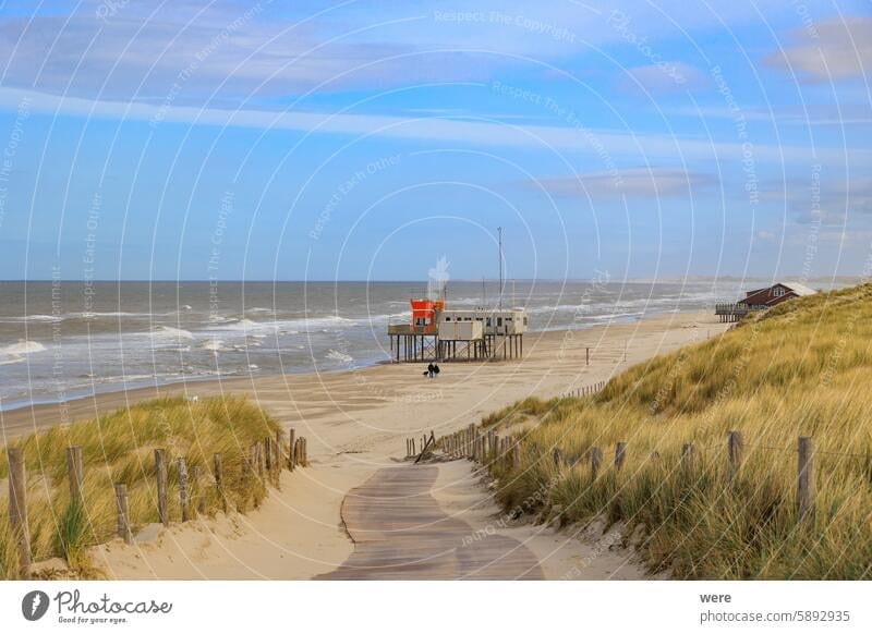 Footpath to the beach with a lifeguard house on a stormy day with cloudy skies in Petten aan Zee in the Netherlands Kinderdijk Oranje Sea Tulips