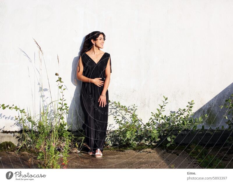 Woman in the setting sun portrait Long-haired Feminine Pantsuit Braids Stand Evening sun Wall (building) Wall (barrier) To enjoy undergrowth plants