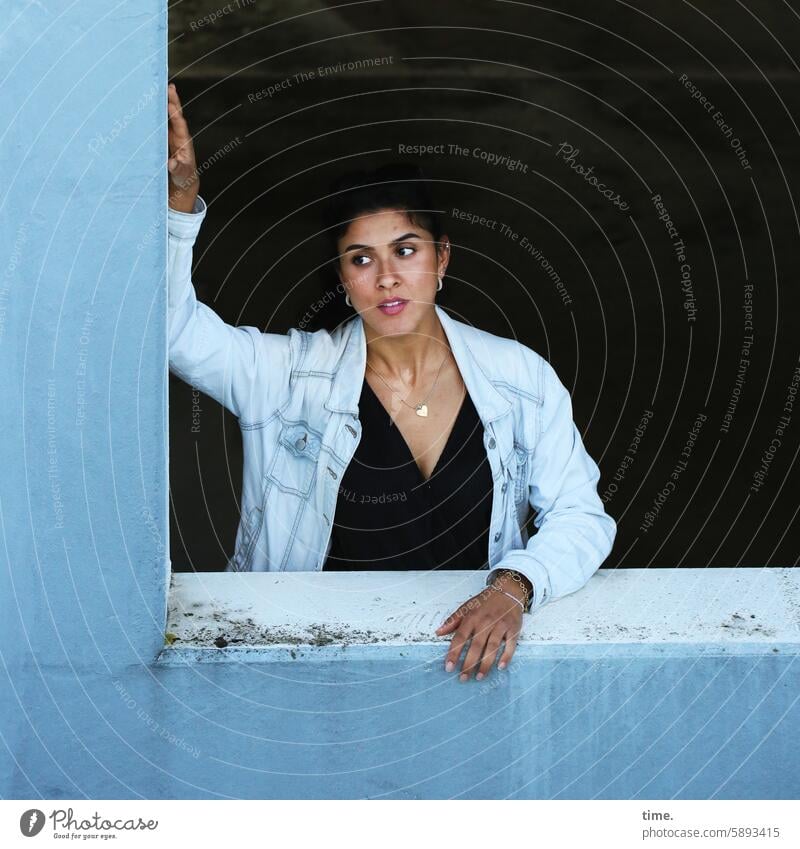 Woman at the window of a parking garage portrait Jeans jacket Concrete Blue Parking garage Feminine Self-confident View to the side Rebel Lean stop Jewellery