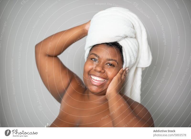 Cheerful plus size black female model woman skin care beauty smile towel happy natural spa complexion human face ethnic african american bath positive cheerful