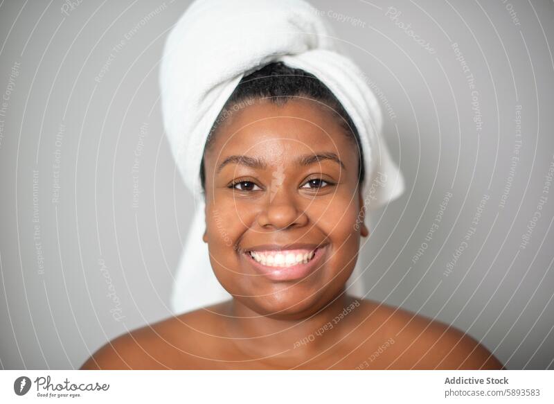 Happy black woman with towel on head smile natural happy beauty skin care spa complexion human face female ethnic african american positive cheerful adult