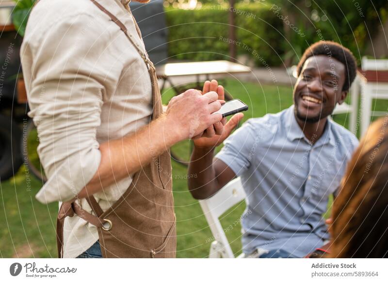 Cheerful black man using smartphone in park gadget device browsing male surfing casual cheerful summer mobile street happy internet lawn online cellphone