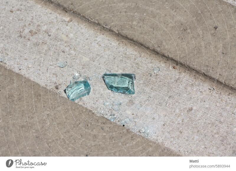 Blue shards of glass on concrete Glass broken glass Trash soiling Concrete Ground sunshine reflection Illuminate Splinter Broken Destruction shattered Damage