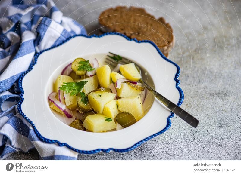 Traditional German potato salad served with bread german boiled red onion fermented cucumber traditional bowl white blue decorative rye vegetable side dish