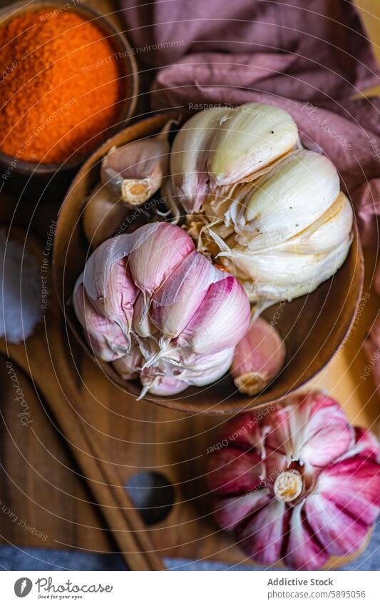 Whole garlic in a bowl and spices in a rustic setting wooden culinary ingredient cooking wooden table clove seasoning cuisine nutrition health raw organic whole