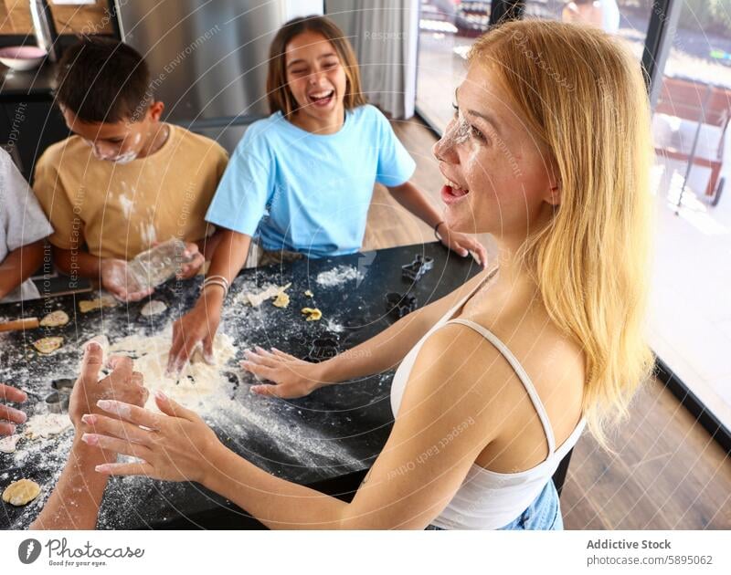 Siblings having fun while cooking together in the kitchen baking flour laughing cookie sibling happiness playful dough homemade casual family bonding activity