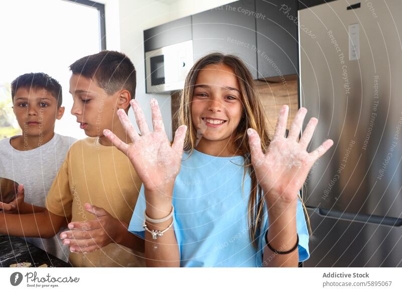 Triplets baking together in a modern kitchen triplet cooking flour siblings girl boy indoor joy smile family fun activity youth dough homemade happy joyful team