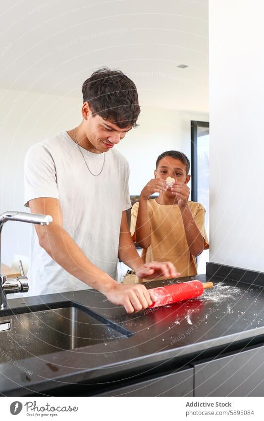 Siblings cooking together in a modern kitchen baking teamwork fun contemporary brother sibling family activity rolling pin flour dough faucet sink counter