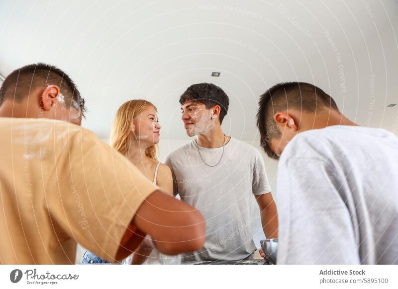 Playful siblings cooking together in the kitchen triplet playful flour face cloth baking family fun joy togetherness domestic interaction indoor casual smiling