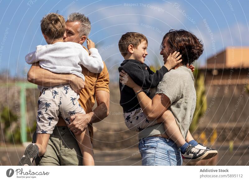 Family enjoying a warm embrace outdoors in autumn family father mother parent child love affection bonding interaction smile cheerful relationship play park