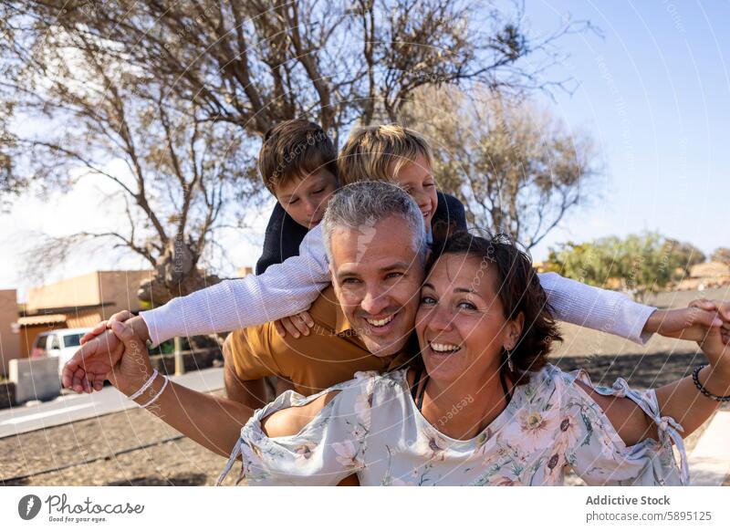 Family of four enjoying a sunny day in the park family playful father mother sons autumn siblings brother smile bonding leisure activity lifestyle weekend fun