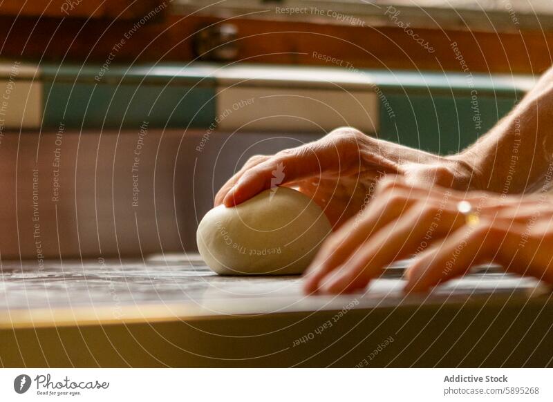 Close-up of hands kneading pizza dough on kitchen counter countertop cooking homemade food preparation baking cuisine chef process culinary fresh ingredient