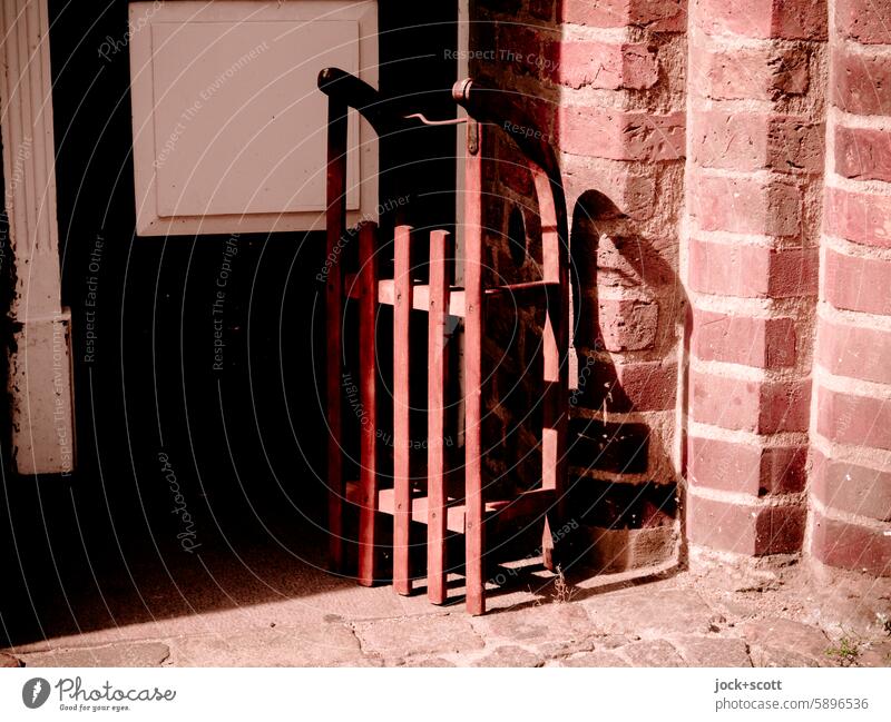 pretty awesome | sledging on the doorstep Sledge Wall (building) Front door urban Sunlight Shadow Sleigh Depth of field warm turned off Shadow play wood sledges