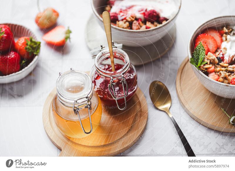 Summer breakfast with yogurt, granola, and fresh strawberries summer strawberry honey jam jar wooden spoon bowl fruit mint healthy meal morning nutritious dairy