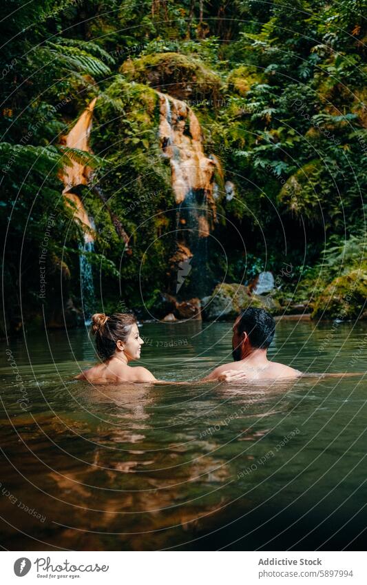 Couple enjoying a serene soak in a jungle hot spring. couple conversation nature relaxation wellness water forest tropical tranquil connection sao miguel azores