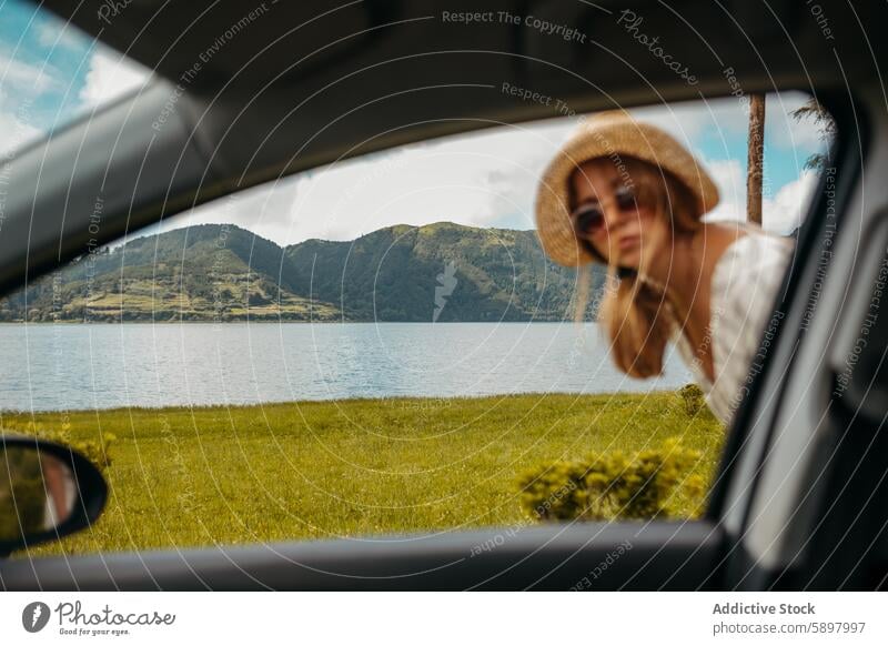Woman enjoying scenic view from car at Sao Miguel, Azores. sao miguel azores woman landscape lake travel nature obscured straw hat sunglasses leisure relaxation