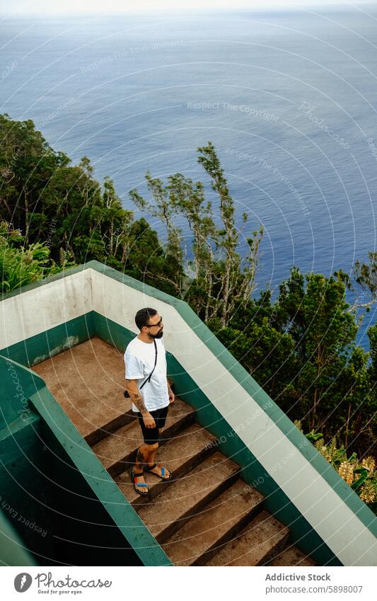 Man on stairs, overlooking the ocean from Sao Miguel. man staircase sao miguel azores view lush foliage landscape sea travel nature outdoor steps exploration