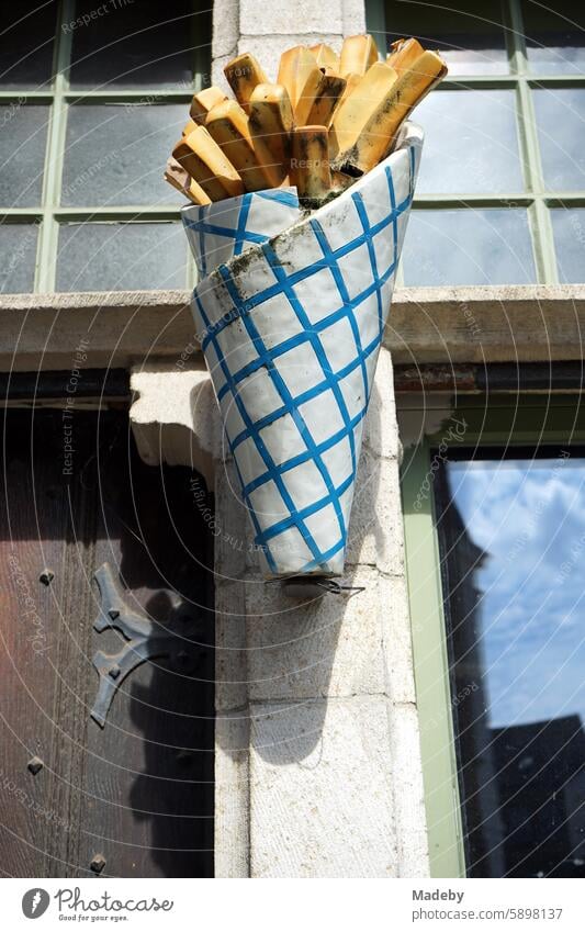 Oversized paper bag with French fries in front of a snack bar in the Hassen of the old town of Ghent in East Flanders, Belgium Lunchtime Facade natural-coloured