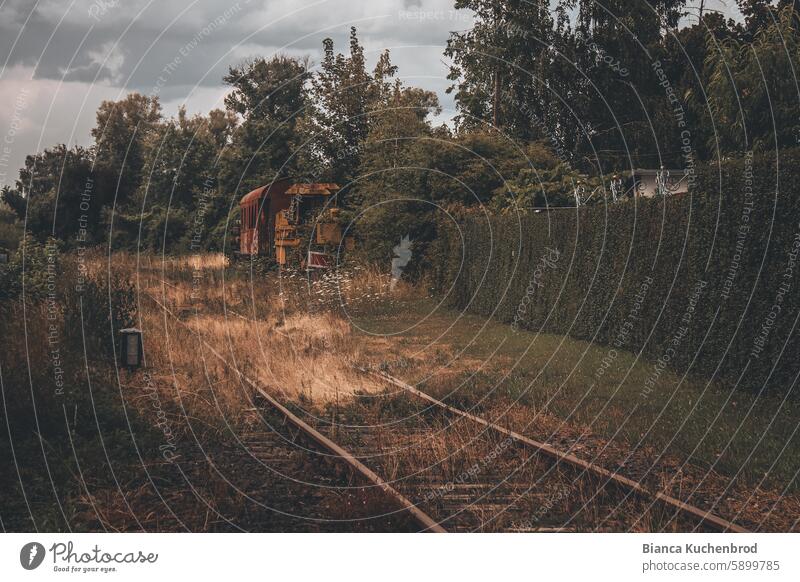 Old railroad tracks of a disused railroad line with a rusty locomotive and wagon at the side. Rail transport Railroad system rails Rail vehicle decommissioned