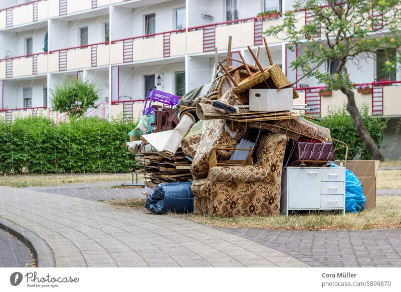 Bulky waste pile with old furniture and household goods in front of a block of flats Bulk rubbish Household Building House (Residential Structure)