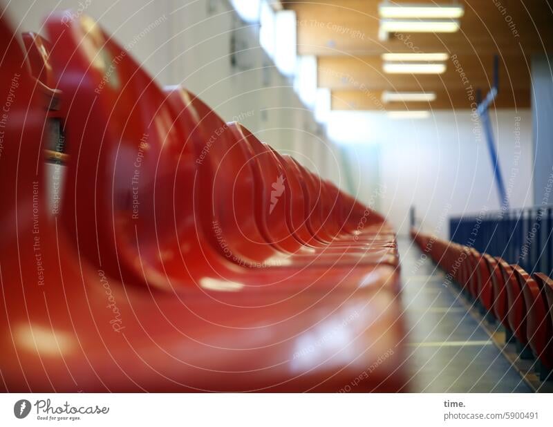 Empty fan mile in a sports hall seat shell Gymnasium Stands Seating Seating capacity Audience Row of chairs Places Sit Hall Red Perspective Corridor