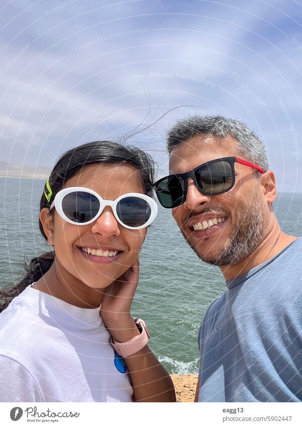 A father and daughter are smiling for a picture person together lifestyle outdoors happy man vacation summer holiday family portrait nature young happiness sea