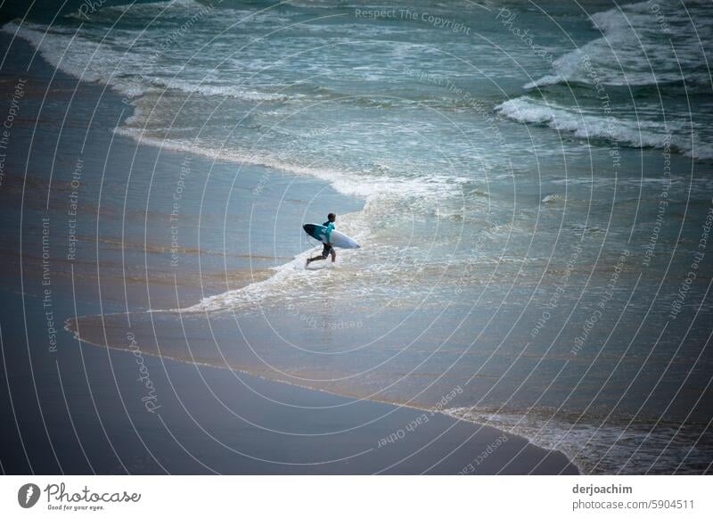 A shortboard athlete goes from the beach to the wavy sea to surf. View from the side Surfing Waves Surfboard Sports Water Ocean Aquatics Man Lifestyle Athletic