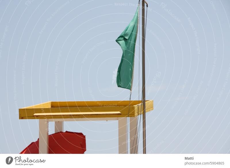 Green flag on the lifeguard's high seat with red parasol Red Flag Hunting Blind rescue swimmer Lifeguard Beach be afloat Ocean Swimming allowed Sky Wind Sand