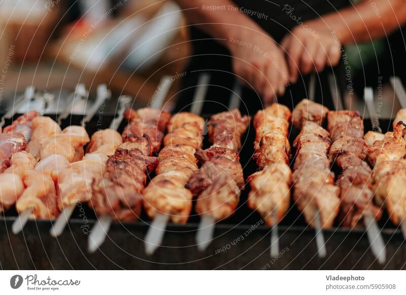 Frying shish kebab on the skewers in brazier. Fresh ruddy meat for barbecue grill on fire outdoor. food cooking roasted pork meal delicious shashlik bbq grilled