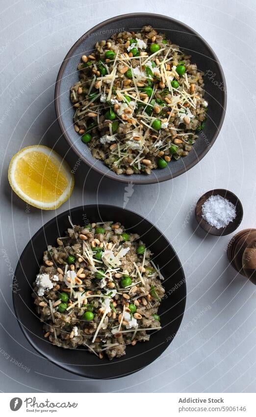 Barley Risotto with Peas and Shaved Cheese Overhead Shot barley risotto peas cheese shaved cheese lemon salt bowl food garnish overhead view meal vegetarian