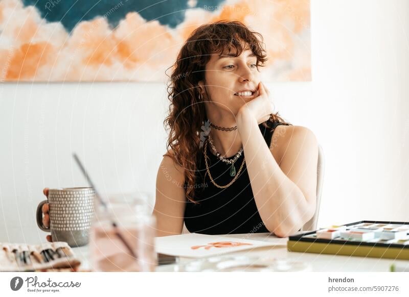 woman artist takes a break while holding a cup one person relaxation creativity indoor coffee cup drinking looking skill hobby enjoyment cheerful sitting