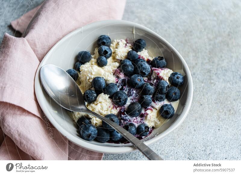 Healthy breakfast with cottage cheese and blueberries healthy blueberry sour cream organic jam ripe bowl spoon gray surface pink napkin nutrition morning meal