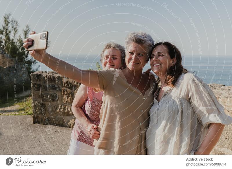 Elderly friends taking a selfie by the seaside elderly women smartphone technology mature ocean mobile phone gadget device camera smiling togetherness outdoor