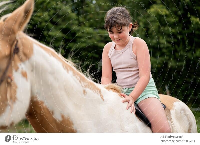 Young girl riding a paint horse in a natural setting young nature outdoors equestrian child animal bonding enjoyment summer countryside rural leisure activity