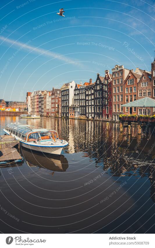 Serene Amsterdam canal scene with traditional buildings and boat amsterdam tour water reflection sky dutch architecture travel tourism cityscape europe