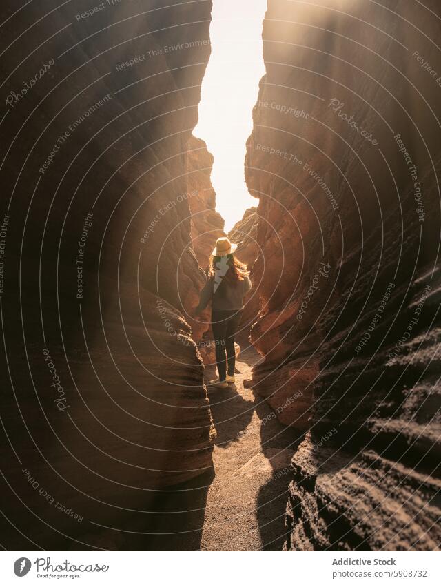 Person Exploring Narrow Rock Passage in Lanzarote person exploring rock passage Canary Islands sunlight adventure narrow rugged textures nature hiking travel