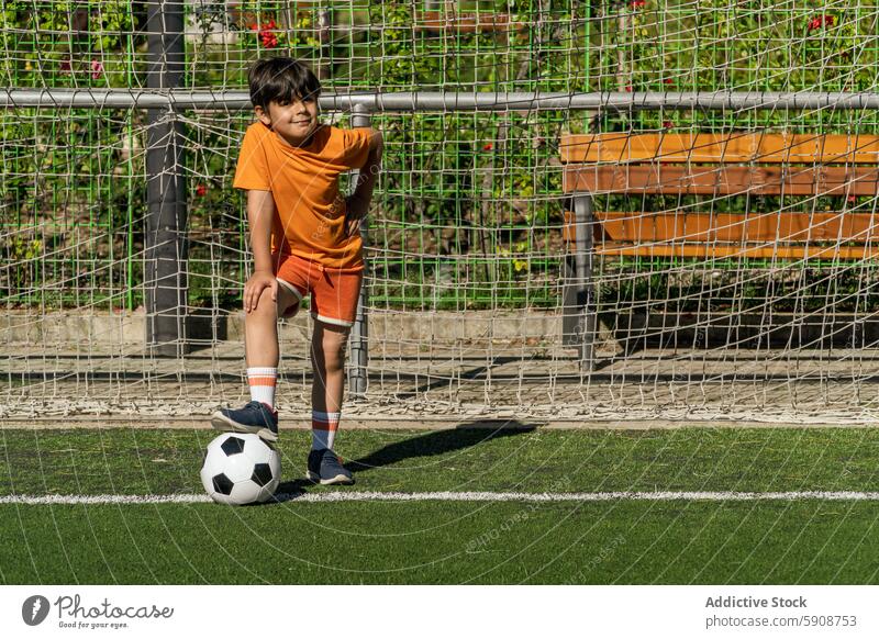 Young boy with soccer ball at the goal post sport play child young outdoor summer field activity team game leisure fun casual lifestyle fitness exercise youth